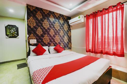 a bedroom with a bed with red curtains and a red wall at SPOT ON Hotel Hyderabad Continental in Hyderabad