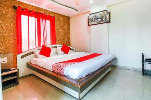 a bedroom with a bed with red pillows on it at SPOT ON Hotel Hyderabad Continental in Hyderabad