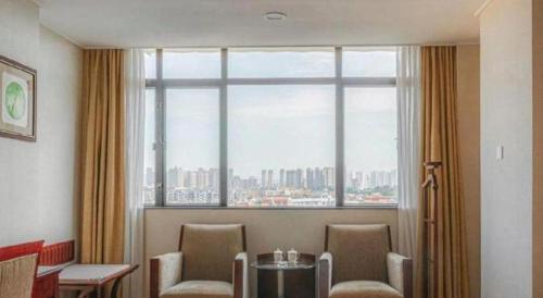 a room with a table and chairs and a large window at Quanzhou Overseas Chinese Hotel in Quanzhou