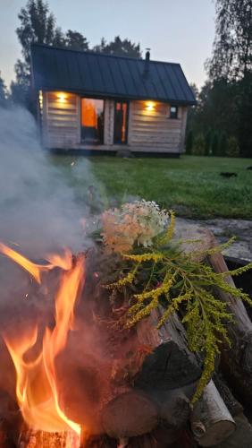 a fire in front of a house with a building at Mājīgs dzīvoklis netālu no jūras in Skulte