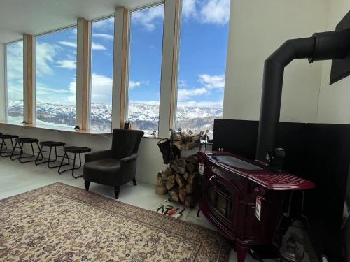 a room with a fireplace and a table and chairs at Snowfox Nozawa in Nozawa Onsen