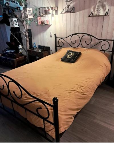 a bedroom with a bed with a black bed frame at La chambre secrète des sorciers in Longueval