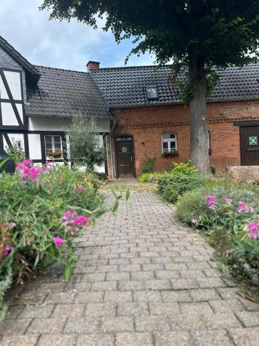 a brick walkway in front of a house with a tree at Hotel Luther Birke Wittenberg in Lutherstadt Wittenberg