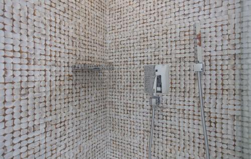 a bathroom with a white tiled wall with a shower at Mareggio Exclusive Residences & Suites in Gythio