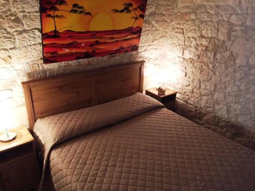Un dormitorio con una cama y un cuadro en la pared. en La Rosa Blu 2, en Santeramo in Colle