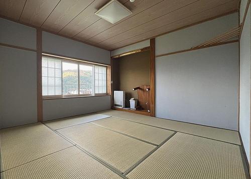 an empty room with a large room with a window at Snowfox Nozawa in Nozawa Onsen
