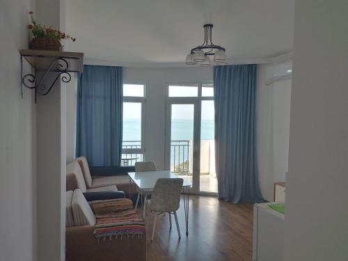a living room with a couch and a table with chairs at 2-х комнатная квартира на берегу моря Колхида in Batumi