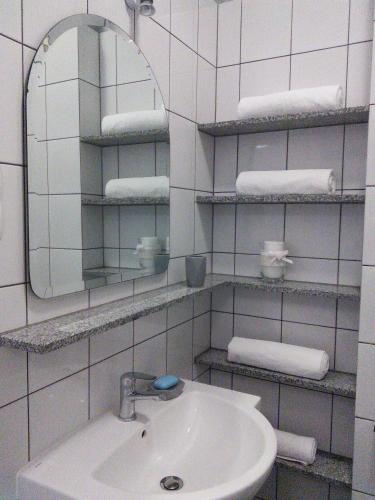 a bathroom with a sink and a mirror and towels at FRESCO Suite & Rooms in Łódź