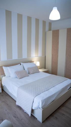a bedroom with a large bed with white sheets at Conte Durini Apartments & Rooms in Arcore