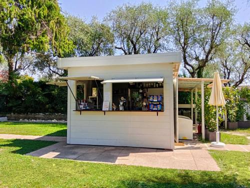 a small kiosk in a yard with a umbrella at Hotel Villa Maria in Desenzano del Garda