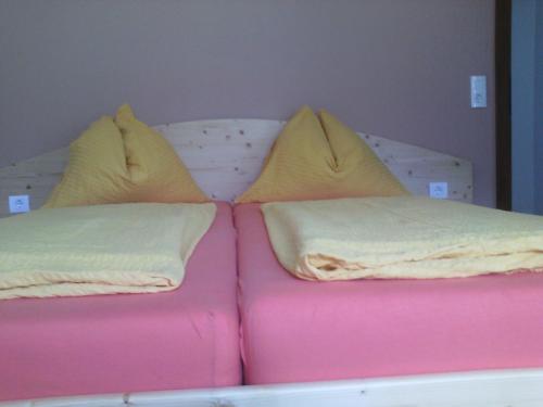 a bed with two pillows on top of it at Appartements Zankl in Kötschach