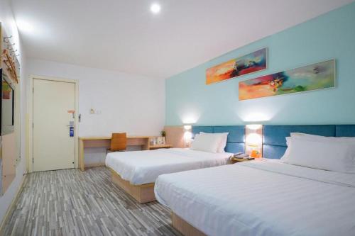 7 Days Inn Wuhan Hanzheng Street Shengli Road Metro Station في ووهان: غرفه فندقيه سريرين ومدخل