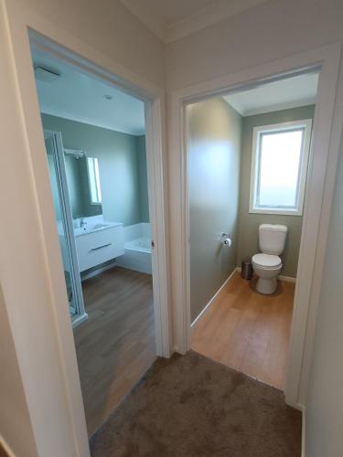 an empty bathroom with a toilet and a window at Brightwater Beauty in Brightwater