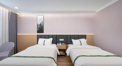 a hotel room with two beds and a desk at GreenTree Inn Linxi International Convention Center Express Hotel in Linyi