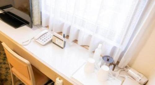 東京にあるHotel IL FIORE Kasai ANNEXの窓付きのデスク、電話が備わります。