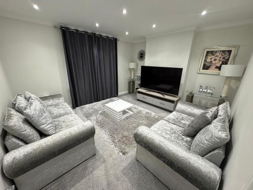 a living room with two couches and a flat screen tv at LUXERY 1 Bedroom Apartment - Falkirk in Falkirk