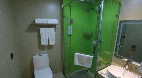 a bathroom with a shower and a toilet and a sink at GreenTree Inn Huayin Huashan Town Huashan Scenicspot Express Hotel in Huayin