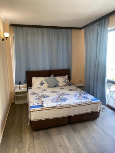 a bedroom with a bed with blue curtains at Къща за гости DOSH in Sozopol