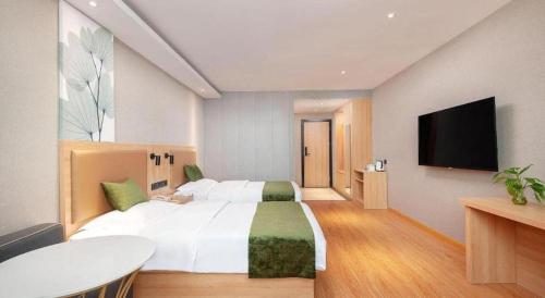 a bedroom with a large white bed and a flat screen tv at GreenTree Inn Shanghai Jiading Anting Motor City Express Hotel in Shanghai