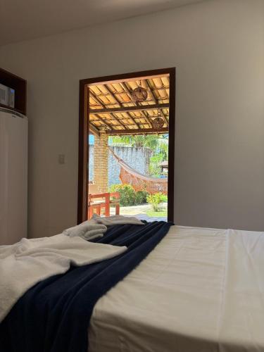 a bed in a bedroom with a view of a patio at Chalé Paraíso, Praia da Pipa in Pipa