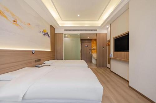 a hotel room with two beds and a flat screen tv at GreenTree Alliance Anhui Hefei South Passenger Station South High Speed Railway Station Hotel in Hefei