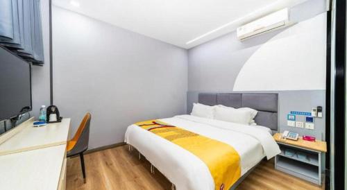 a bedroom with a large white bed and a desk at Pai Hotel Xi'an Electronic Zheng Street in Xi'an
