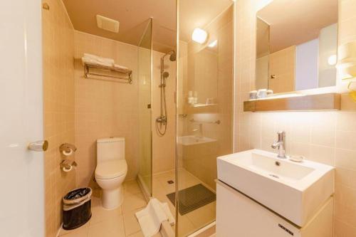 a bathroom with a toilet and a sink and a shower at Jinjiang Inn Select Foshan Nanhai Guicheng Metro Station in Nanhai