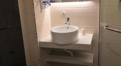 a white sink in a bathroom with a shower at 7 Days Premium Hotel Ji'an Taihe Gongnongbing Avenue in Ji'an