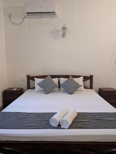 a bedroom with a bed with two towels on it at Kaz N Ray Apartment Negombo in Negombo