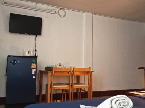 a room with a table and a tv and a refrigerator at Apartment near Central Festival Hatyai in Hat Yai