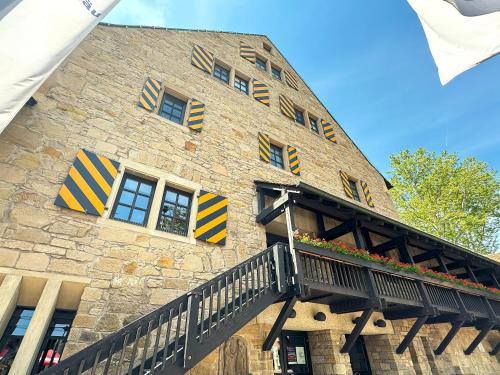 a stone building with a balcony on the side of it at Herzogskelter Hotel & Restaurant in Güglingen
