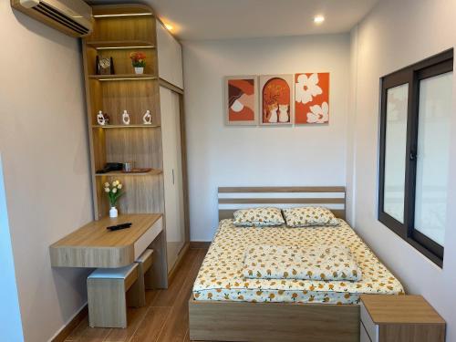 a small bedroom with a bed and a desk at The Rose House-Lakeview Long Bien in Hanoi