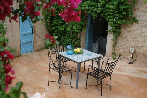 un tavolo e sedie in un cortile fiorito di Son Vent a Caʼs Concos