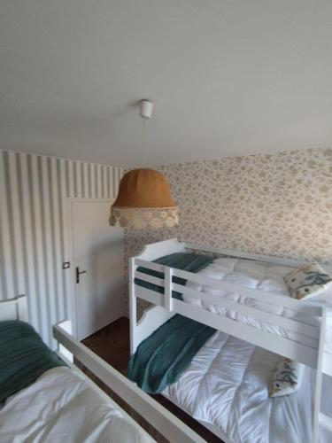 a bedroom with two bunk beds and a lamp at Gîte L'Apothicaire in Montaigu-Vendée