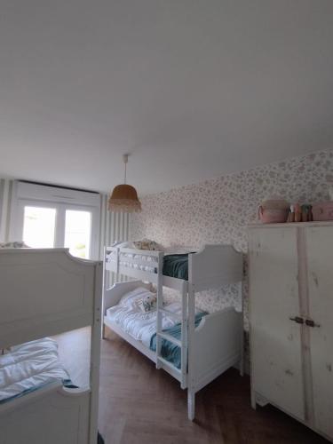 a bedroom with two bunk beds and a window at Gîte L'Apothicaire in Montaigu-Vendée