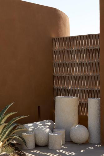a group of white vases sitting next to a wall at ADĀMA - A Signature Collection by Zálo Spaces - Adults Only in Matala