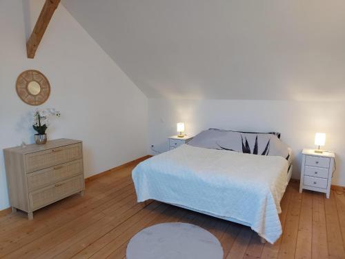 a bedroom with a bed and a dresser and two lamps at La maison de Valentine in Theneuille