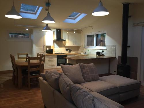 a living room with a couch and a kitchen at Shellow Lane Lodges in Congleton