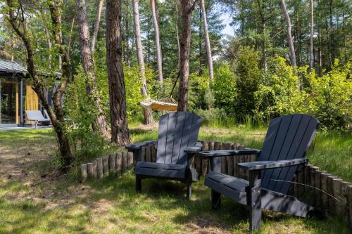 two chairs and a table in a yard at Design bungalow met wellness in parkbos in Giethmen
