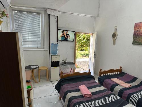 two beds in a room with a tv on the wall at Rooms Struga in Struga