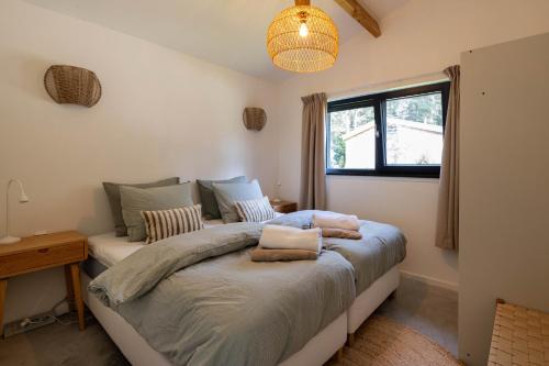 a bedroom with a bed and a window at Design bungalow met wellness in parkbos in Giethmen