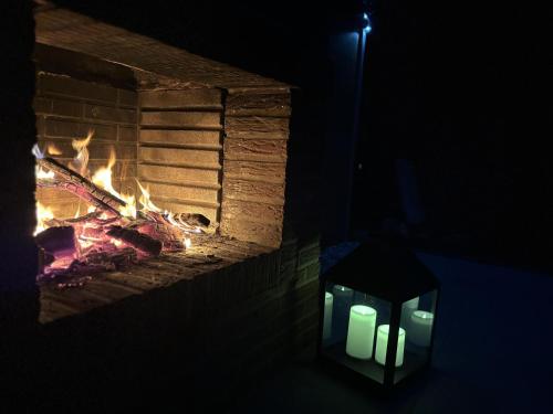 a fireplace with candles in front of it with a lantern at Ferienhaus Lamia in Bispingen