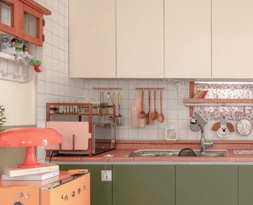 een keuken met witte kasten en een spoelbak bij The Cozy Oven in Busan