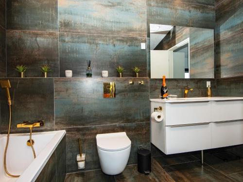a bathroom with a tub and a toilet and a sink at 10 person holiday home in Vinderup-By Traum in Vinderup