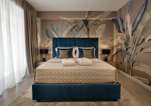 a bedroom with a blue bed with two pillows at Giorgio Raggi Hospitality in Terni
