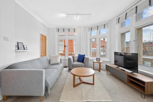 a living room with a couch and a tv at 1 Bedroom Apartment Near Leicester Square in London