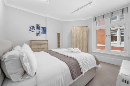 a white bedroom with a large bed and a window at 1 Bedroom Apartment Near Leicester Square in London