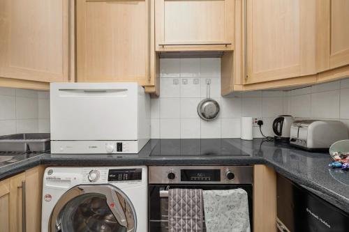 a kitchen with a washing machine in a kitchen at 1 Bedroom Apartment Near Leicester Square in London