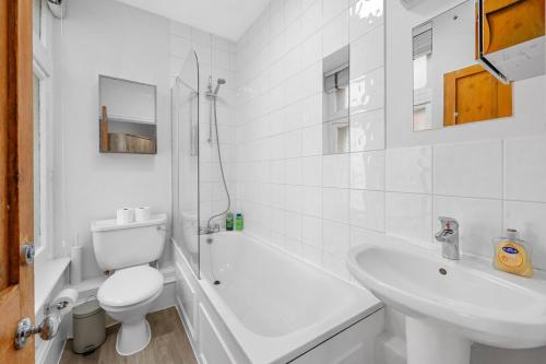 a white bathroom with a toilet and a sink at 1 Bedroom Apartment Near Leicester Square in London