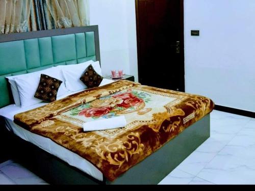 a bedroom with a large bed with a green headboard at Subhan Palace Guest House in Karachi